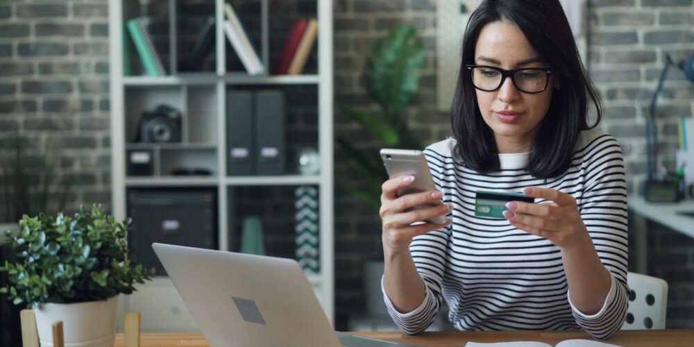 a woman sitting at a table looking at her cell phone