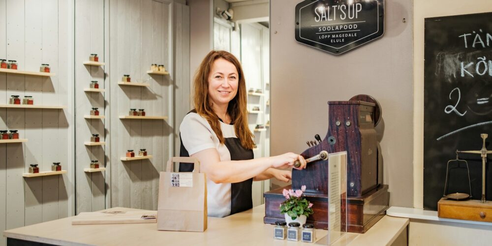 woman in white shirt standing beside brown wooden table